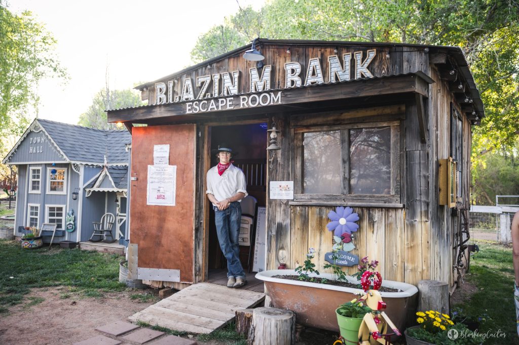 Person standing at entrance of rustic escape room with old west theme.