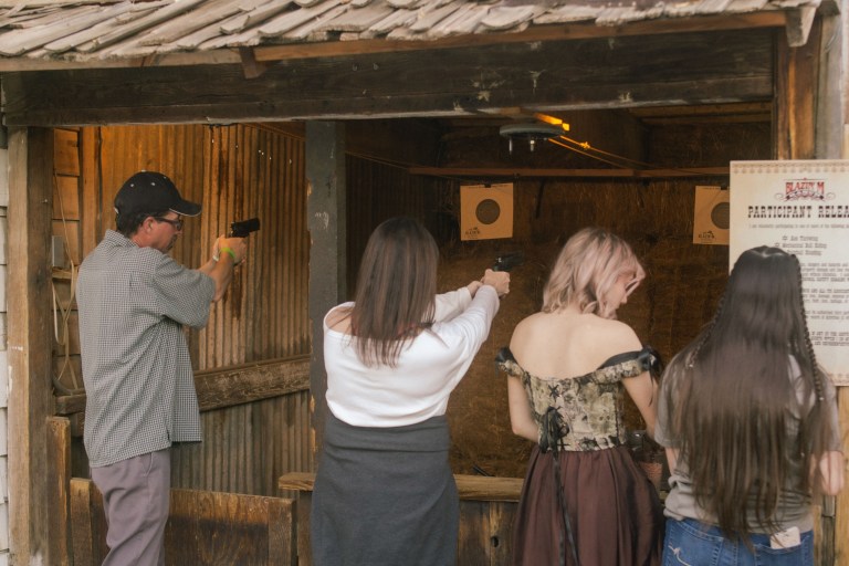 People target shooting with guns at an indoor range.